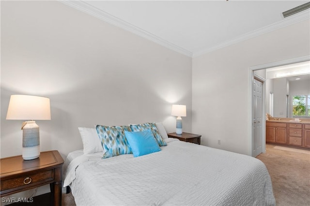 bedroom with crown molding, light carpet, and ensuite bathroom