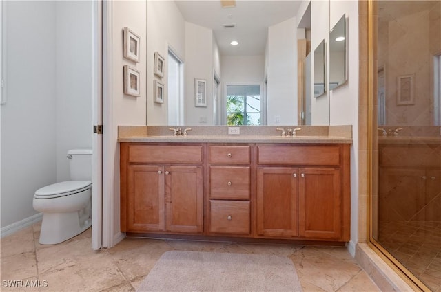 full bathroom with a shower stall, toilet, double vanity, and baseboards