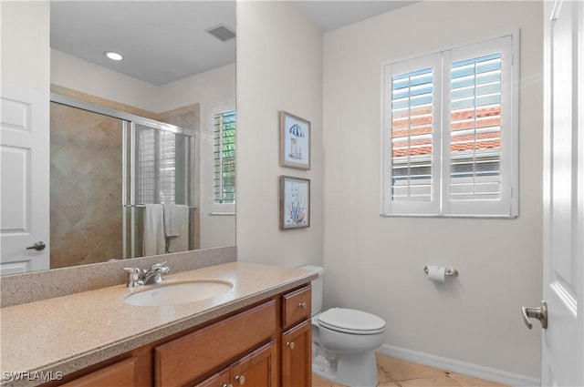 bathroom featuring a stall shower, toilet, vanity, tile patterned floors, and baseboards