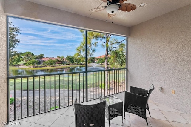 sunroom featuring a water view