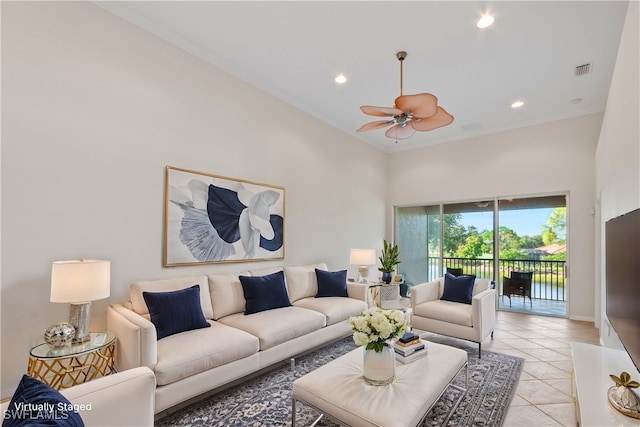 living room featuring a high ceiling, crown molding, light tile patterned floors, and ceiling fan