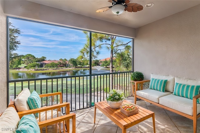 sunroom / solarium featuring ceiling fan, a water view, and a wealth of natural light