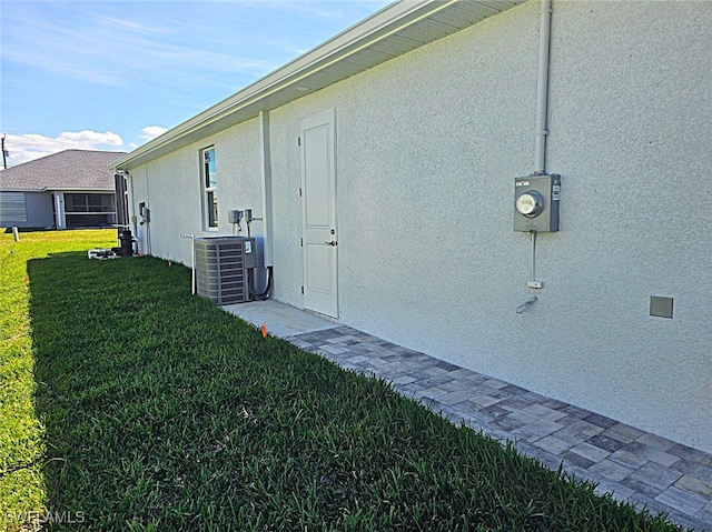 exterior space with a yard and central AC