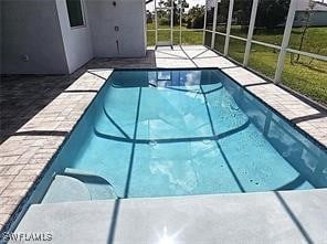 view of swimming pool with a patio area and glass enclosure