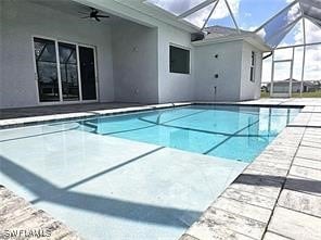 view of pool featuring ceiling fan, a patio, and a lanai