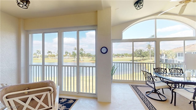 sunroom featuring a water view and ceiling fan