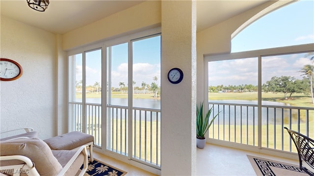 sunroom featuring a water view