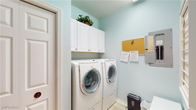 washroom featuring cabinets, electric panel, and separate washer and dryer