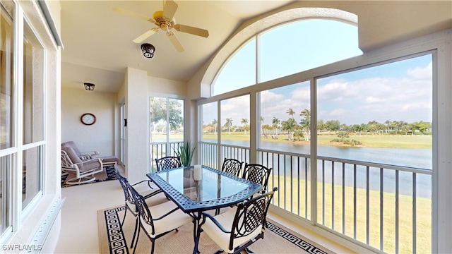 sunroom with lofted ceiling, a water view, and ceiling fan