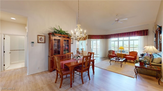 dining room with light hardwood / wood-style flooring and ceiling fan with notable chandelier