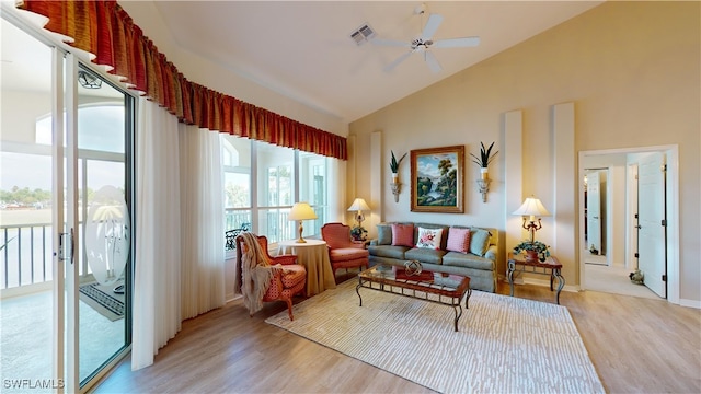 living room with light hardwood / wood-style floors, vaulted ceiling, and ceiling fan