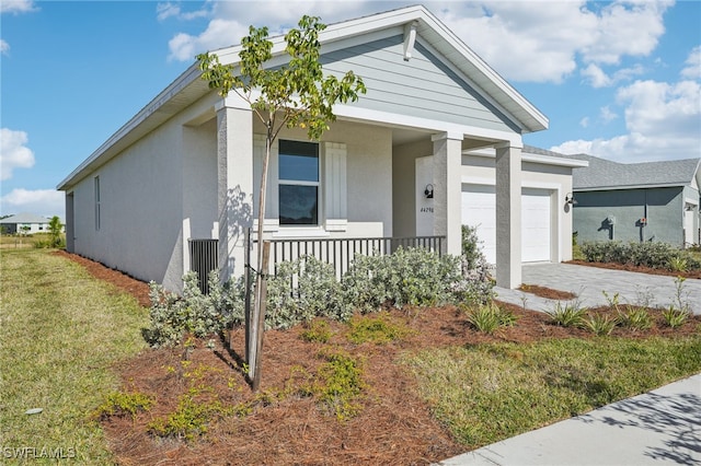 view of front of property with a garage, covered porch, and a front lawn