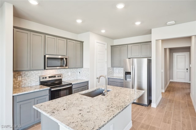 44290 Frontier Dr, Punta Gorda, FL 33982 - kitchen with a kitchen island with sink, sink, light stone countertops, and appliances with stainless steel finishes