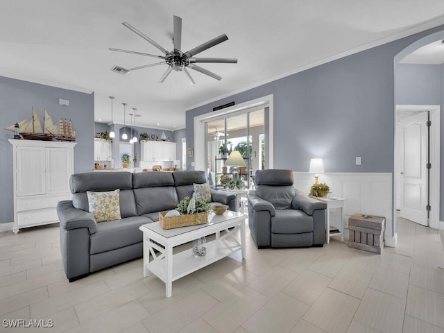 living room featuring ceiling fan, light tile patterned floors, and ornamental molding