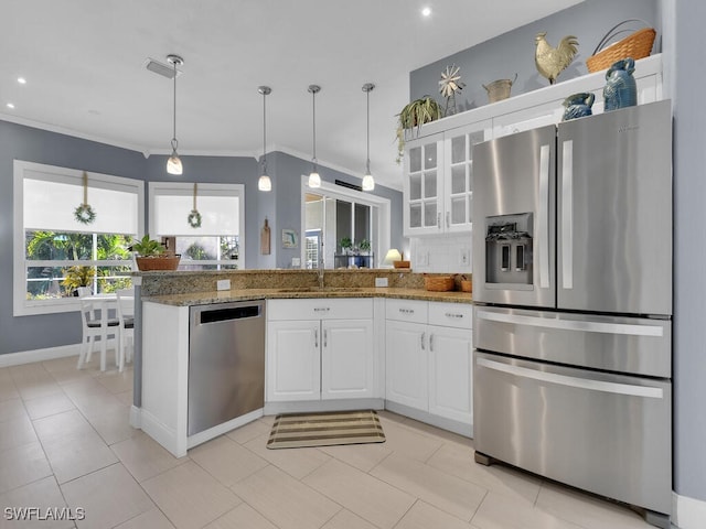 kitchen featuring sink, appliances with stainless steel finishes, dark stone counters, and white cabinetry