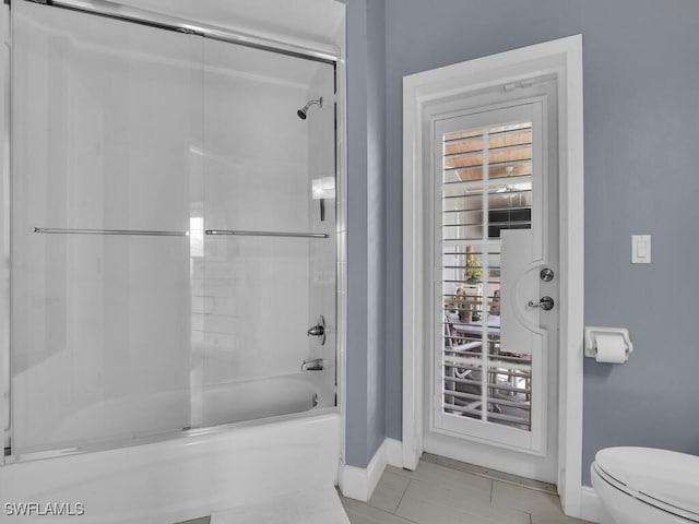 bathroom featuring toilet, enclosed tub / shower combo, and tile patterned floors