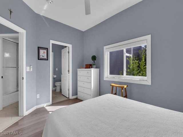 bedroom featuring ceiling fan, ensuite bathroom, and light hardwood / wood-style flooring