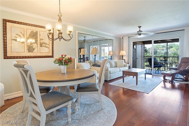 dining space with ceiling fan with notable chandelier, dark hardwood / wood-style flooring, and crown molding