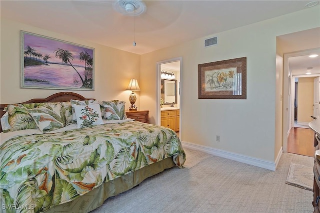 bedroom with sink, ceiling fan, ensuite bathroom, and light carpet