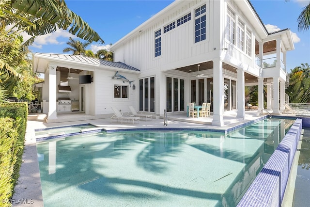 back of house featuring ceiling fan, area for grilling, a fenced in pool, and a patio