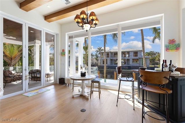 sunroom / solarium featuring beamed ceiling and a notable chandelier