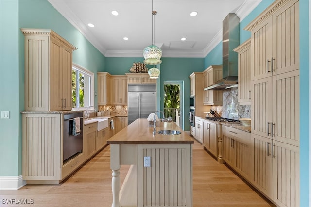 kitchen featuring stainless steel appliances, sink, a center island with sink, light hardwood / wood-style flooring, and hanging light fixtures