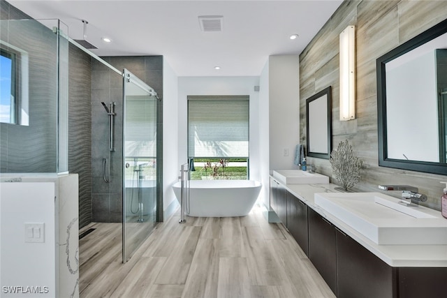 bathroom featuring hardwood / wood-style floors, vanity, and separate shower and tub