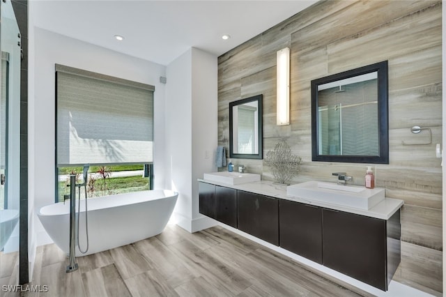 bathroom featuring hardwood / wood-style flooring, vanity, shower with separate bathtub, and tile walls