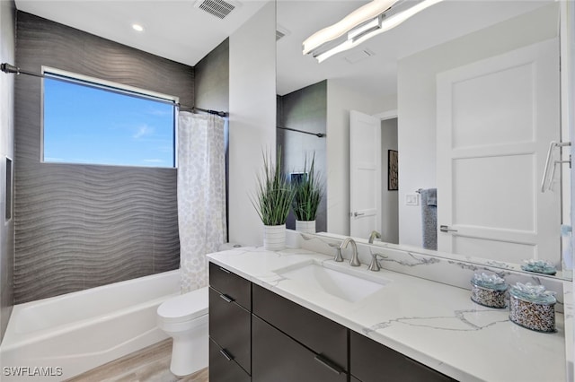 full bathroom featuring hardwood / wood-style floors, vanity, toilet, and shower / bath combination with curtain