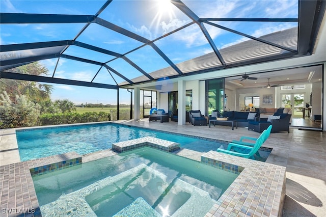 view of pool featuring glass enclosure, an outdoor hangout area, ceiling fan, an in ground hot tub, and a patio