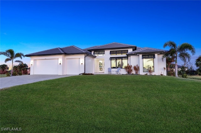 prairie-style home with a garage and a lawn