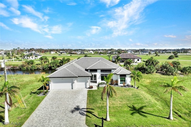 single story home featuring a garage, a water view, and a front yard