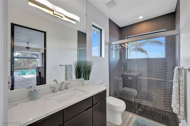 bathroom featuring hardwood / wood-style flooring, vanity, ceiling fan, and an enclosed shower