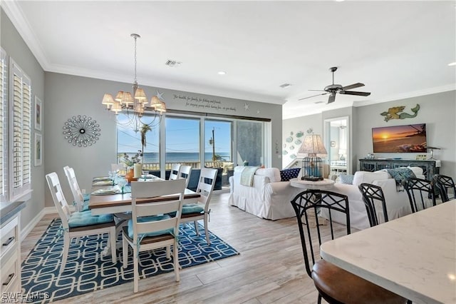 dining area with crown molding, light hardwood / wood-style flooring, and ceiling fan with notable chandelier