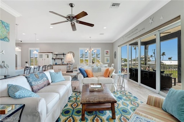 living room featuring light hardwood / wood-style floors, ceiling fan with notable chandelier, and ornamental molding