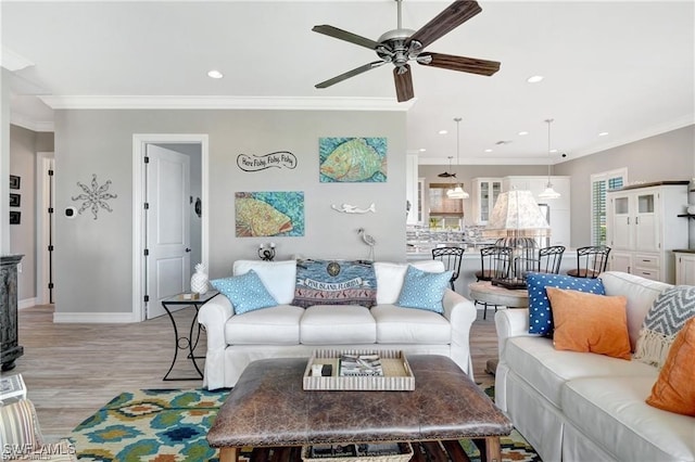 living room with crown molding, ceiling fan, and light wood-type flooring