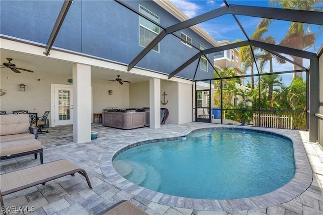 view of swimming pool with ceiling fan, a lanai, a patio, and a hot tub