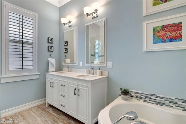 bathroom with hardwood / wood-style floors, vanity, a bath, and a wealth of natural light