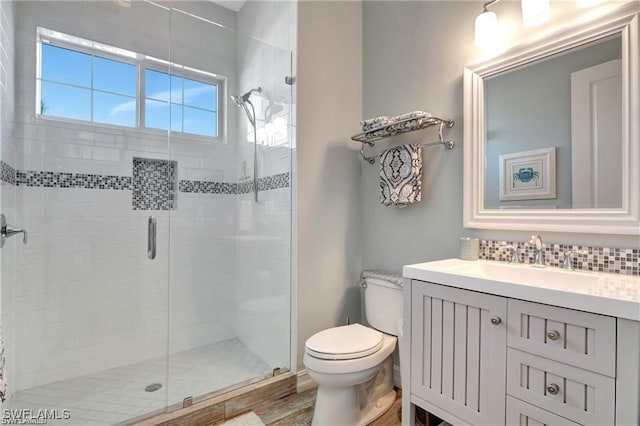 bathroom with toilet, vanity, an enclosed shower, and hardwood / wood-style flooring