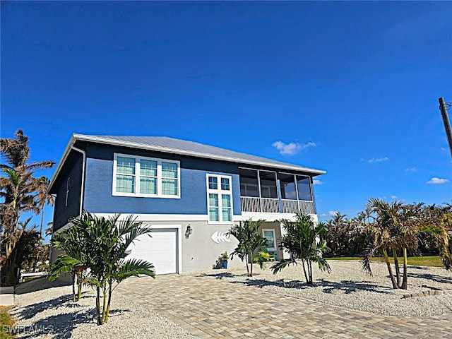 view of front of home with a sunroom and a garage