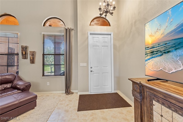 tiled entrance foyer featuring an inviting chandelier