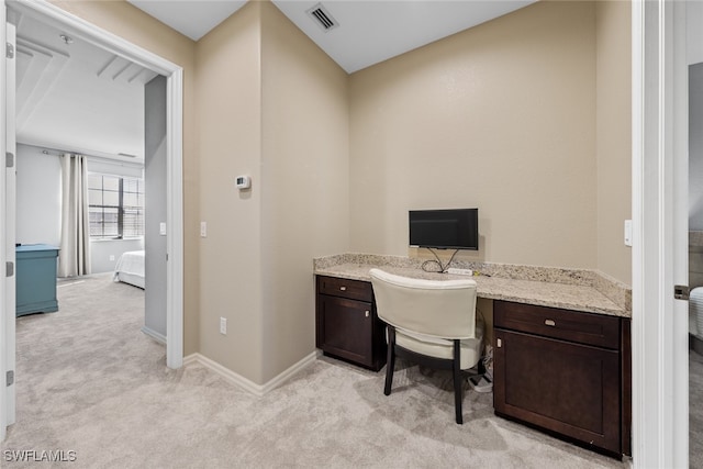 office space featuring built in desk and light carpet