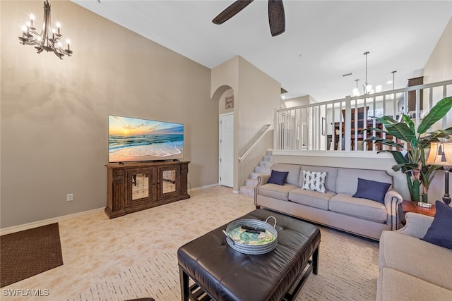 carpeted living room featuring ceiling fan with notable chandelier