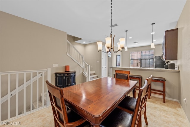 tiled dining room with a notable chandelier and sink