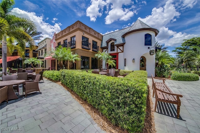 view of front of home featuring a patio, an outdoor living space, and a balcony