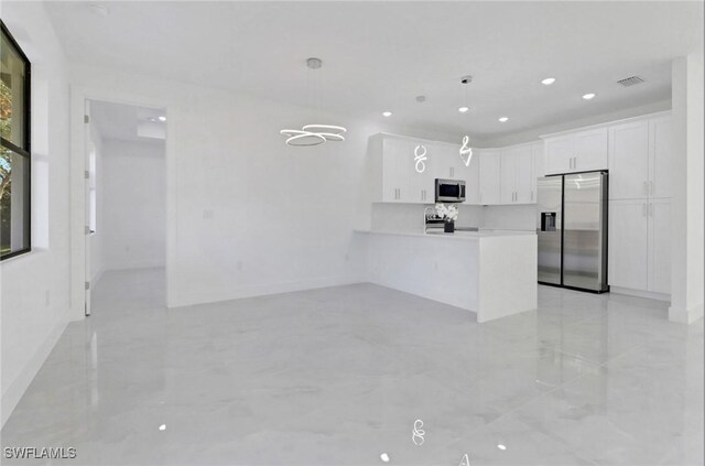 kitchen featuring pendant lighting, white cabinetry, kitchen peninsula, and appliances with stainless steel finishes