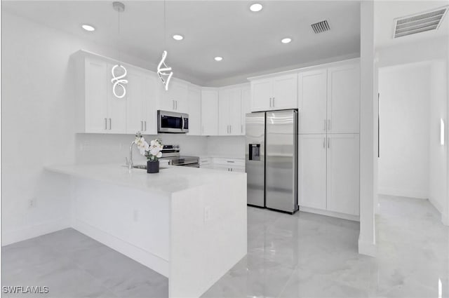 kitchen with kitchen peninsula, stainless steel appliances, white cabinetry, and sink