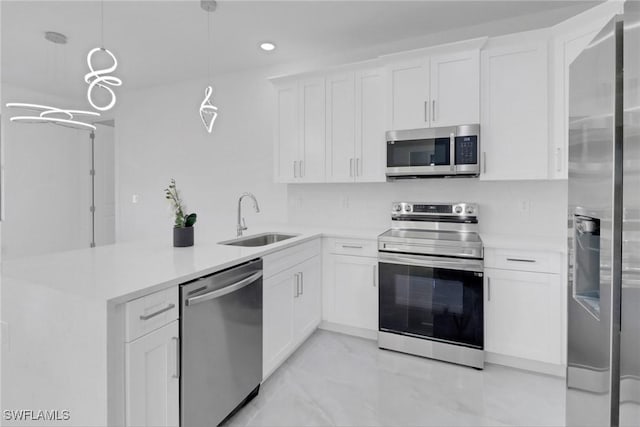 kitchen with white cabinets, hanging light fixtures, sink, and appliances with stainless steel finishes