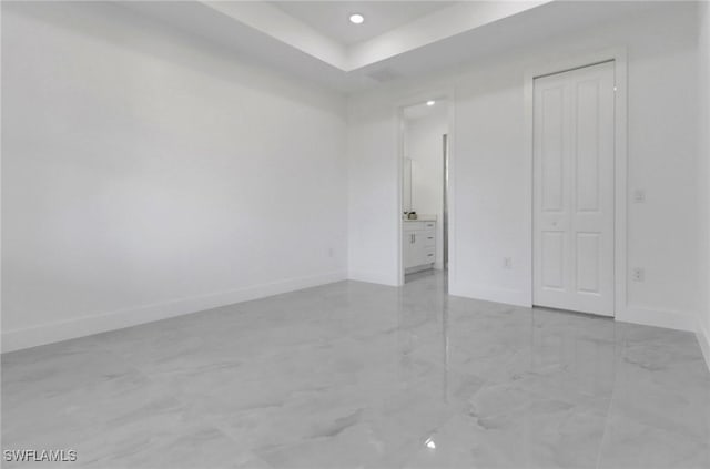 unfurnished bedroom featuring a raised ceiling