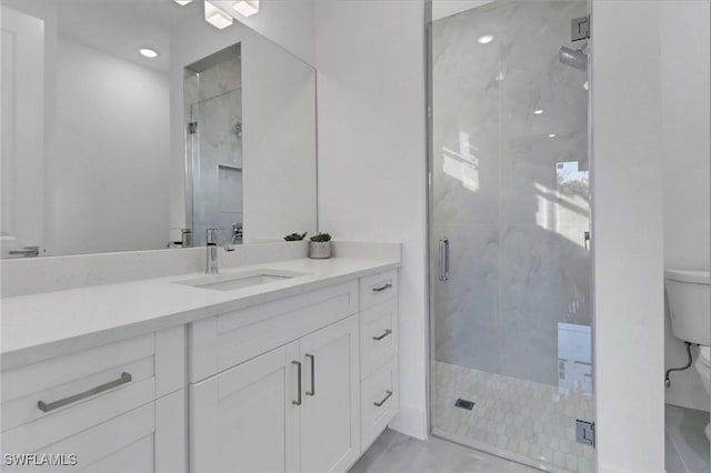 bathroom featuring vanity, toilet, and a shower with shower door